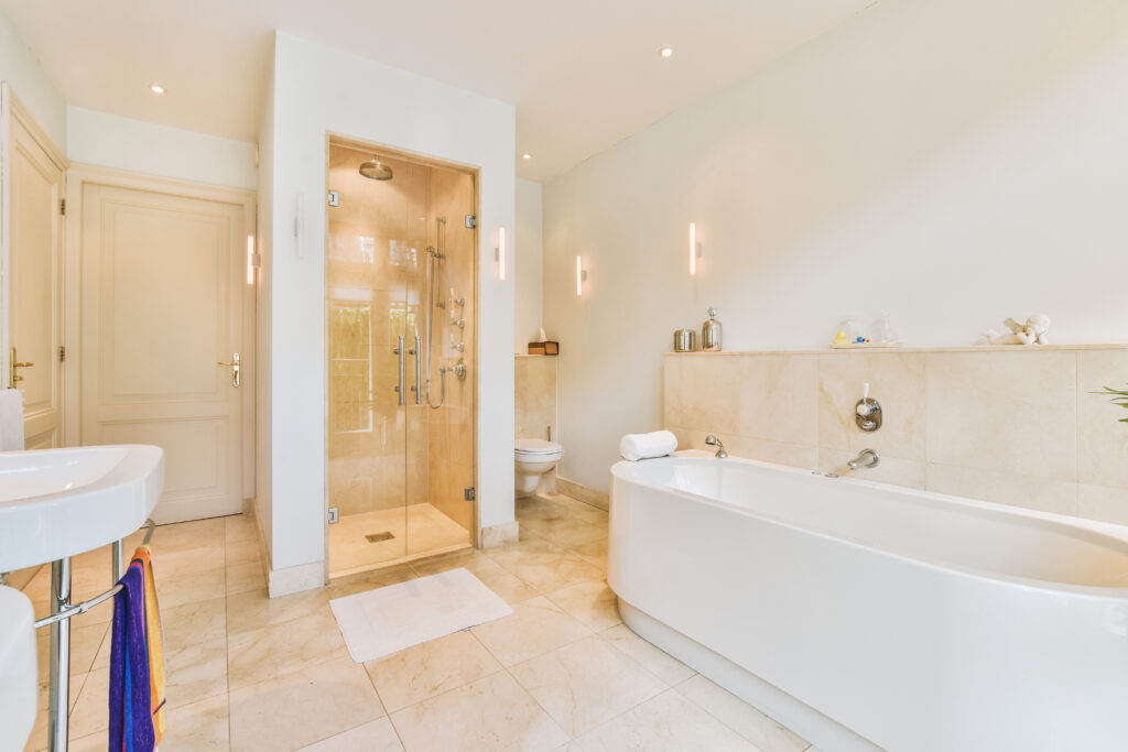 A bathroom with a shower cabin, large bathtub, and sinks, offering a clean and relaxing atmosphere.